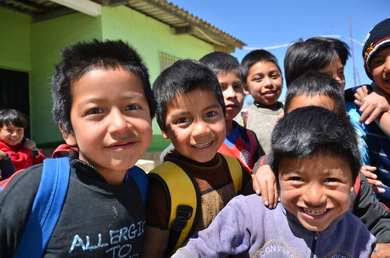 Smiling schoolchildren crowd together for the camera