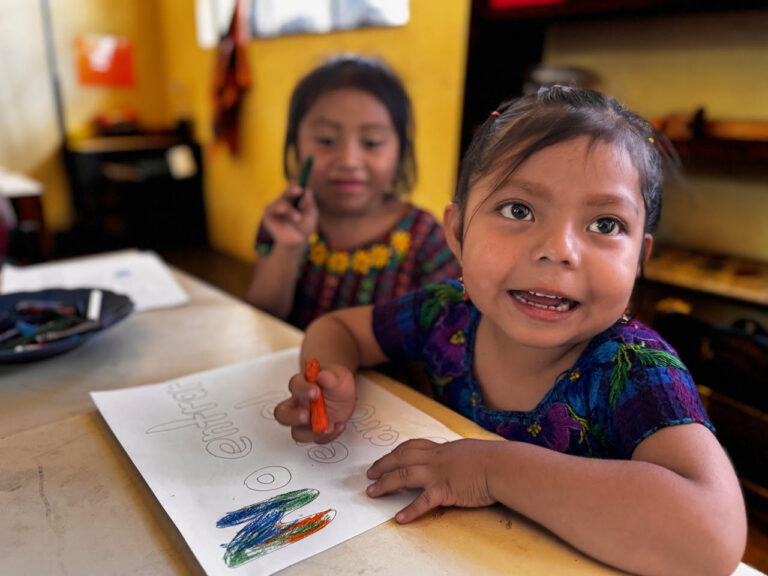 Two girls coloring at their classroom table